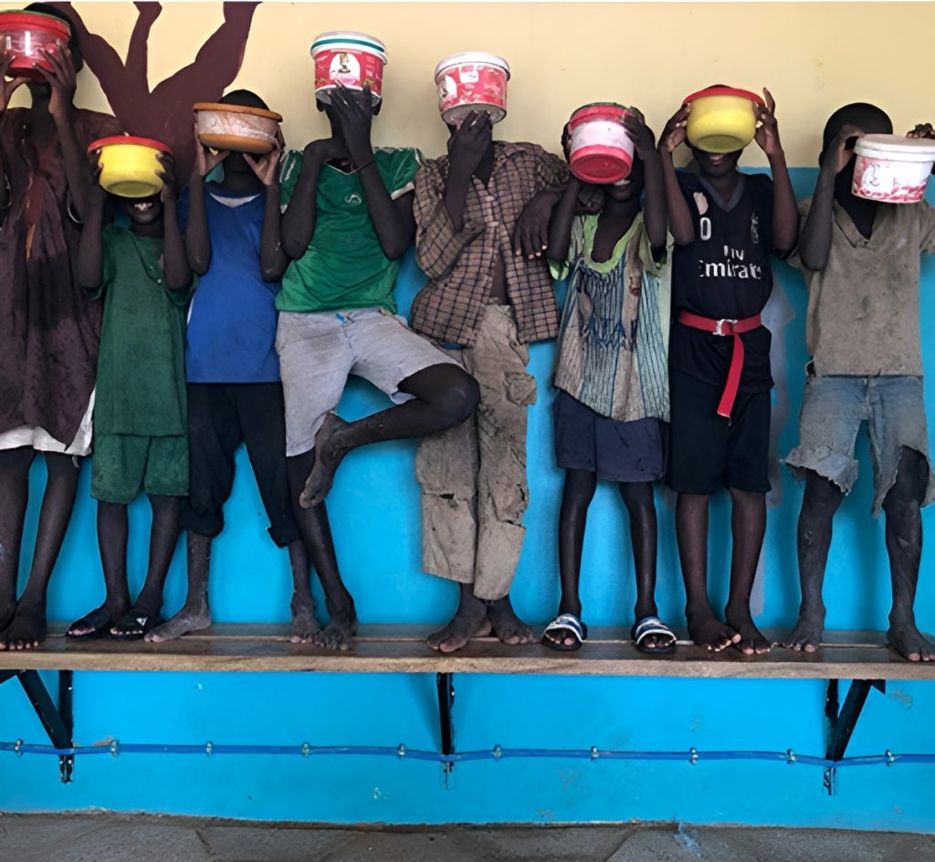 Grupo de talibés con latas rojas, herramienta que utilizan para guardar las monedas o alimentos que consiguen cuando van a mendigar. Foto: Fundación Farrah